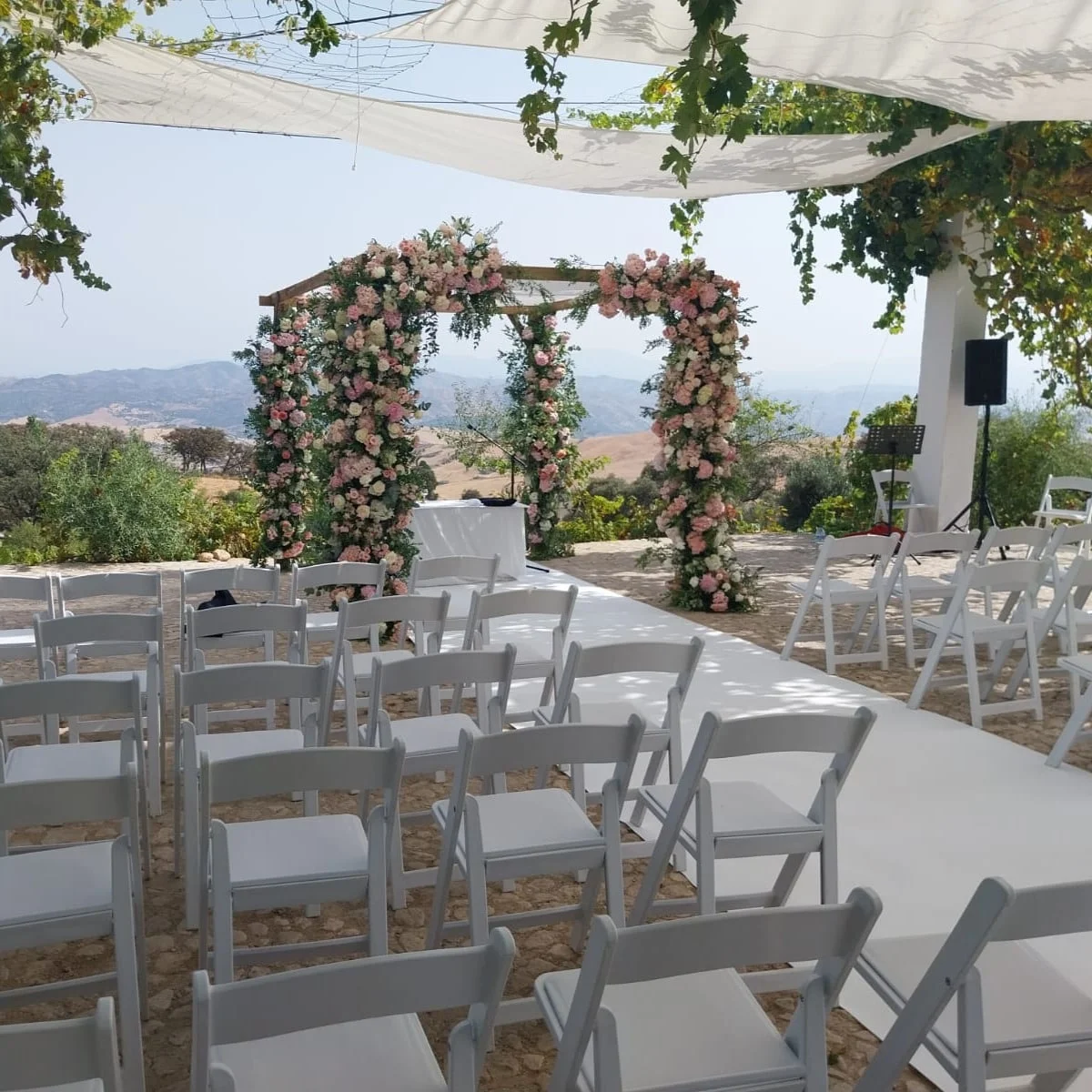 Huppa decorated with white and pink flowers for a Jewish wedding in Antequera, Malaga, with mountain views.