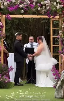 A rabbi performing a Jewish wedding ceremony under a huppah in Barcelona, Spain, for Ariella and Jonathan