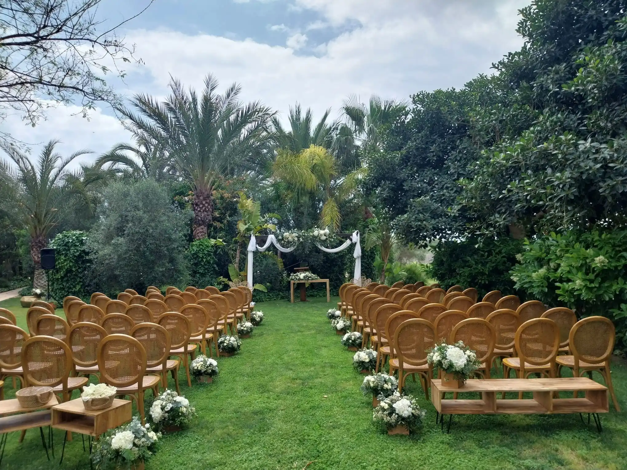 upá decorada con flores blancas en los jardines de El Roalet de Kiko durante una ceremonia de boda judía e interreligiosa en Alicante.